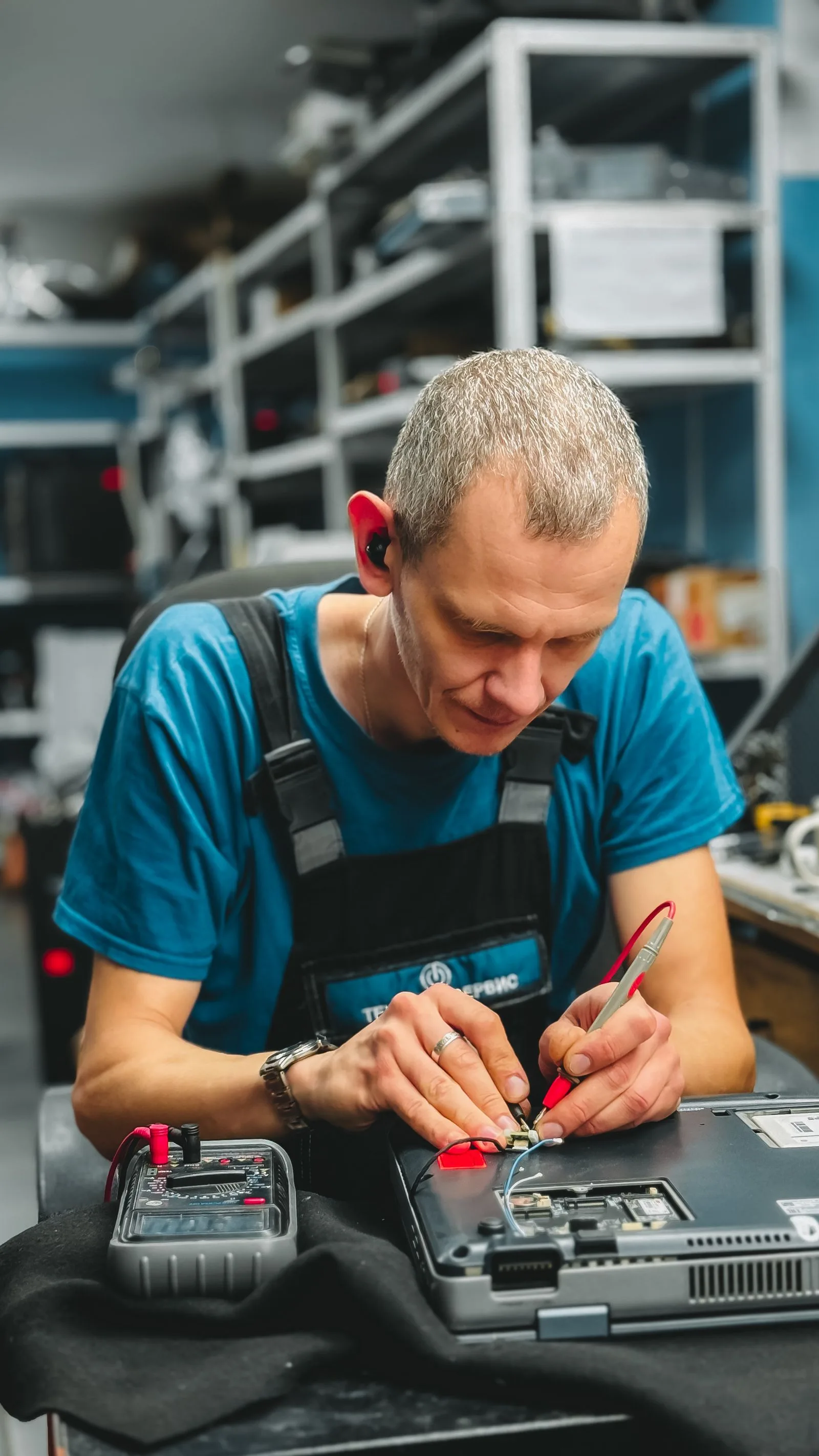 A technician repairing a laptop motherboard in a modern workshop