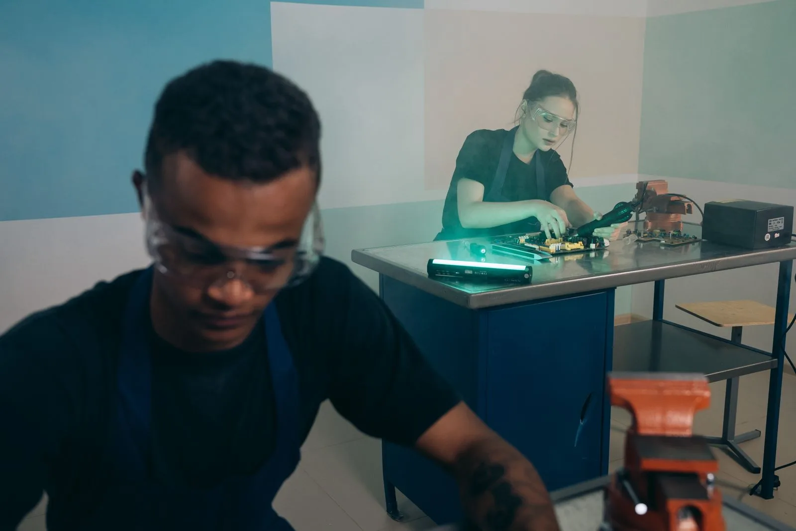 A man and woman working together at a technical workstation